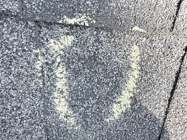 Chalk circle around a hail hit on an architectural shingle