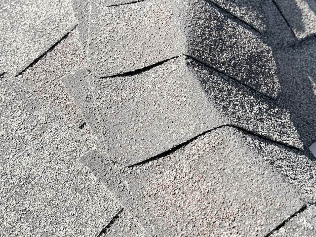 Hip cap shingles running up the hip of an asphalt shingle roof