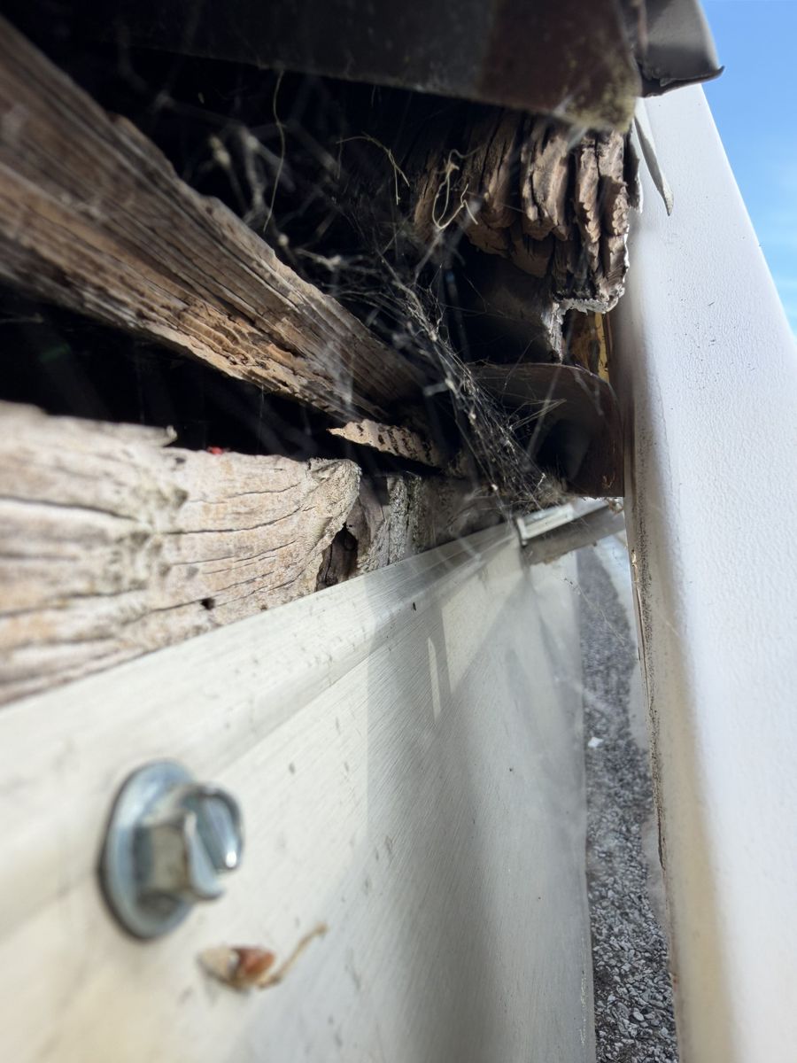Crumbling, rotted wood behind the back of a gutter